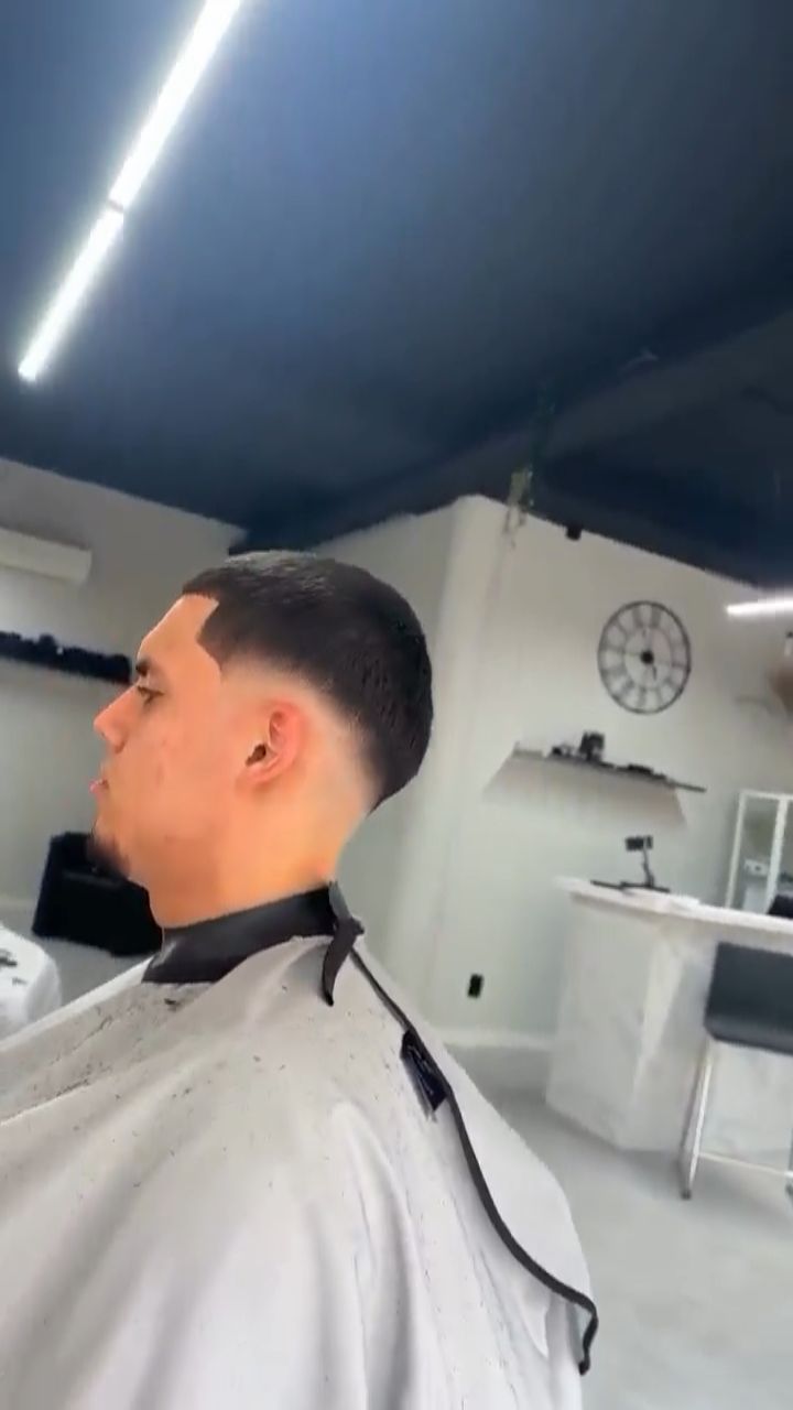 Zijaanzicht van een verse fade, in de zaak van Excellence Hair met de wandklok op de achtergrond